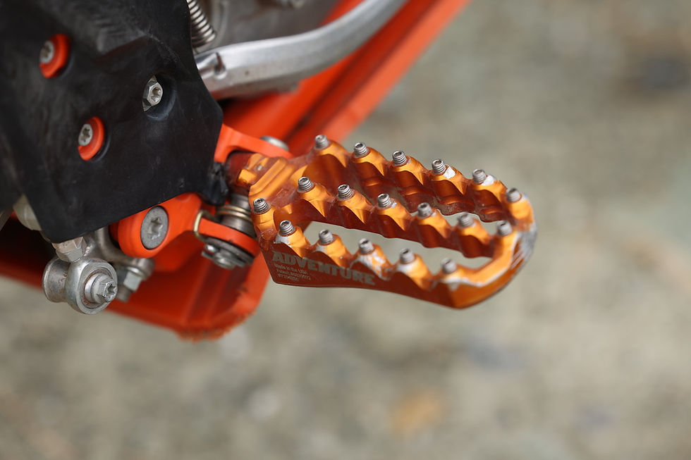 a set of hi tech orange motorcycle footpegs