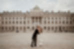 Couple dancing in an empty courtyard, embracing each other. Elegant historic Somerset House in central London as backdrop to their wedding venue, under a cloudy sky, creating a romantic mood.