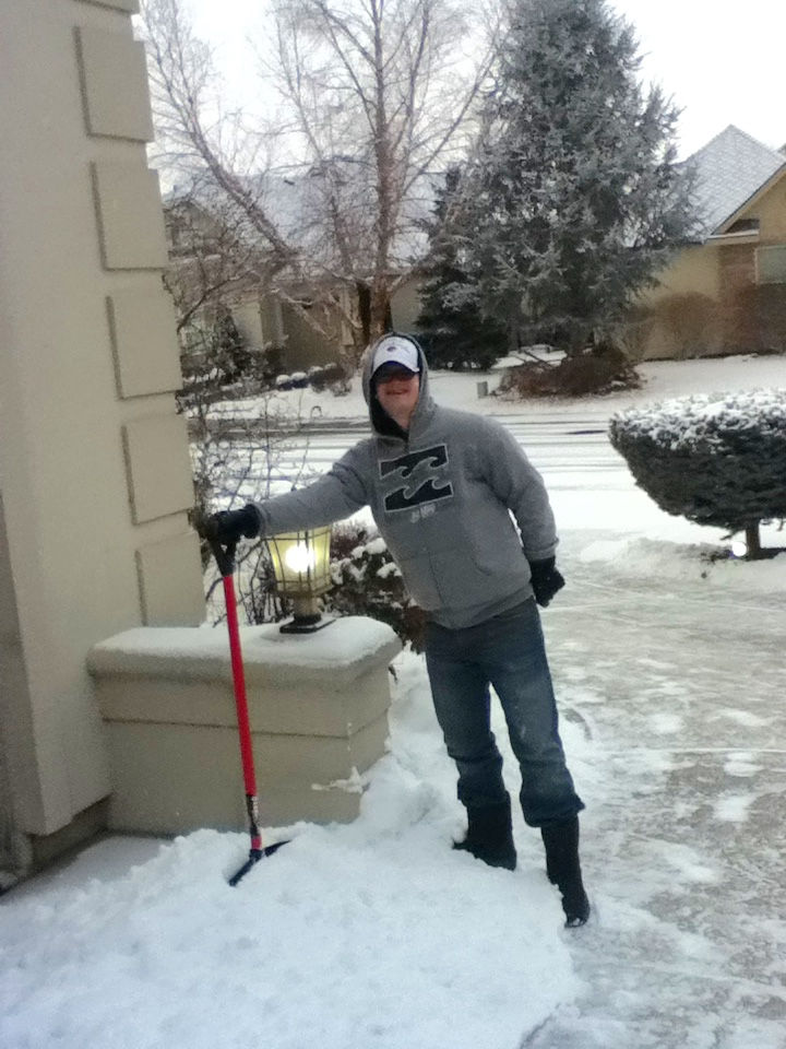 Mark dressed for winter cold shoveling snow from the driveway.