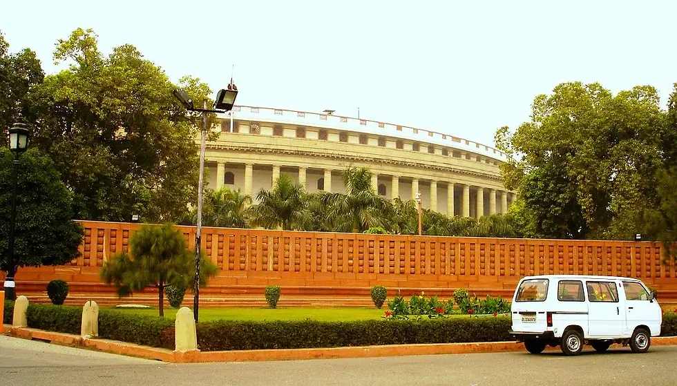 Indian parliament with a white tata omni van in the foreground