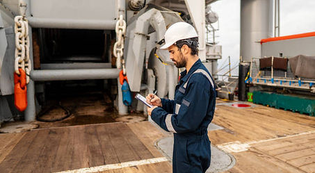 Worker using mobile phone on vessel deck during offshore operations