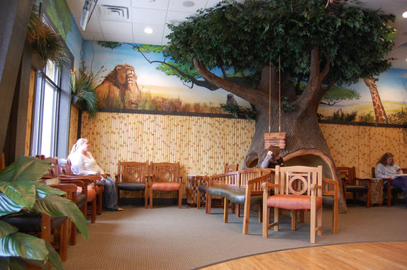 A waiting room with a safari themed mural and bamboo motifs on the wall. theme fusion