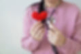 A Woman holding a heart and stethoscope to show heart care.