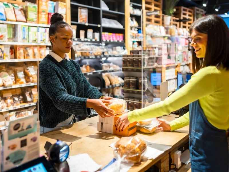 Kundin kauft gesundes Brot im Biomarkt.