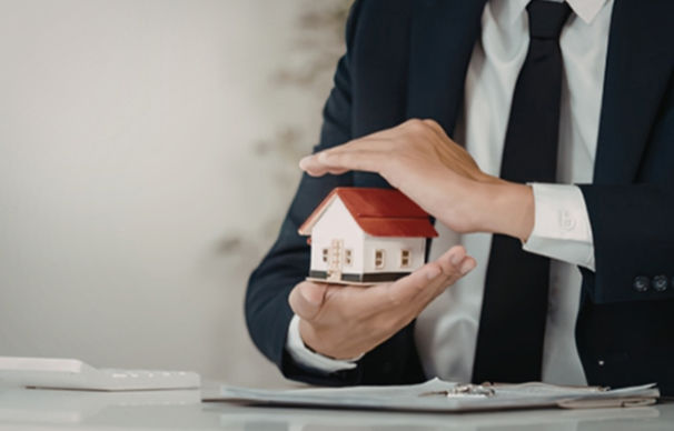 Professional holding a miniature house model representing South Florida Airbnb property management and top earning vacation rental strategies