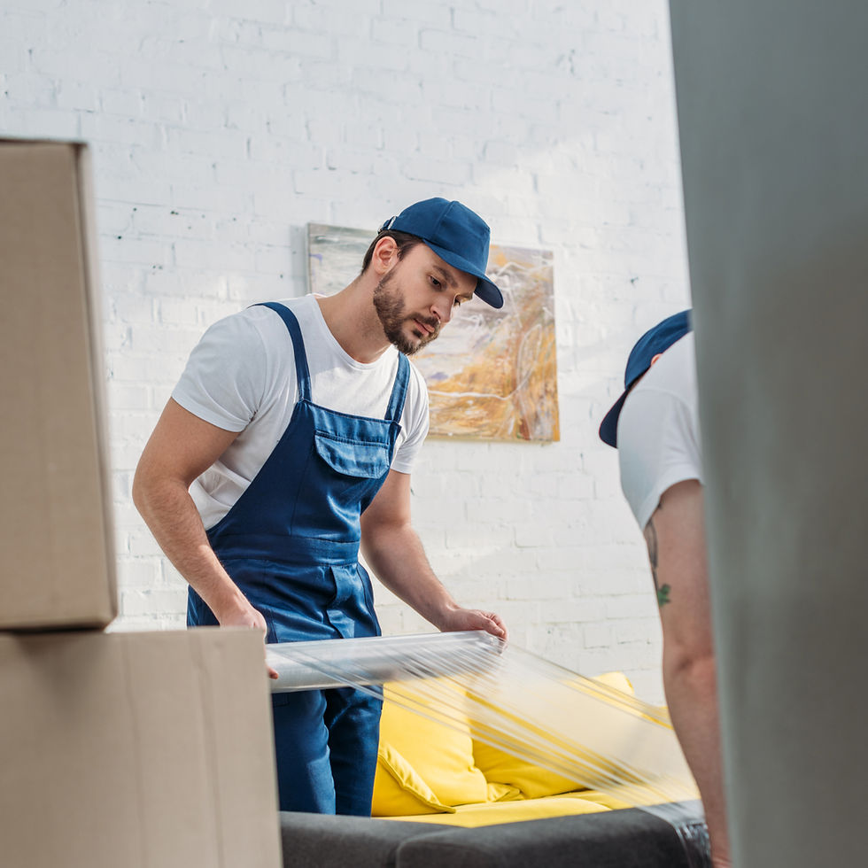 selective-focus-movers-wrapping-couch-with-roll-stretch-film-apartment_edited