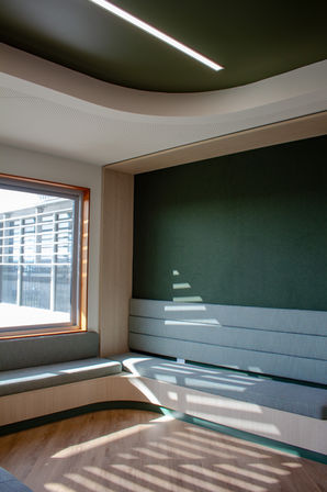 Waiting area at Kala Primary School with integrated corner bench seating and green acoustic wall treatment by BACH Commercial.
