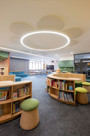 Circular acoustic ceiling panels arranged around an integrated ring light above the refurbished library.