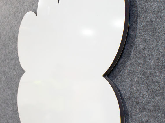 Close-up view of a custom speech bubble whiteboard mounted on a grey acoustic wall