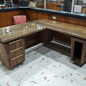 Custom L-shaped wood office desk with storage drawers.