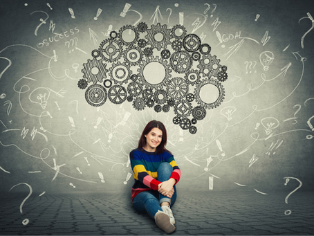 Young woman sitting under depiction of brain as a machine