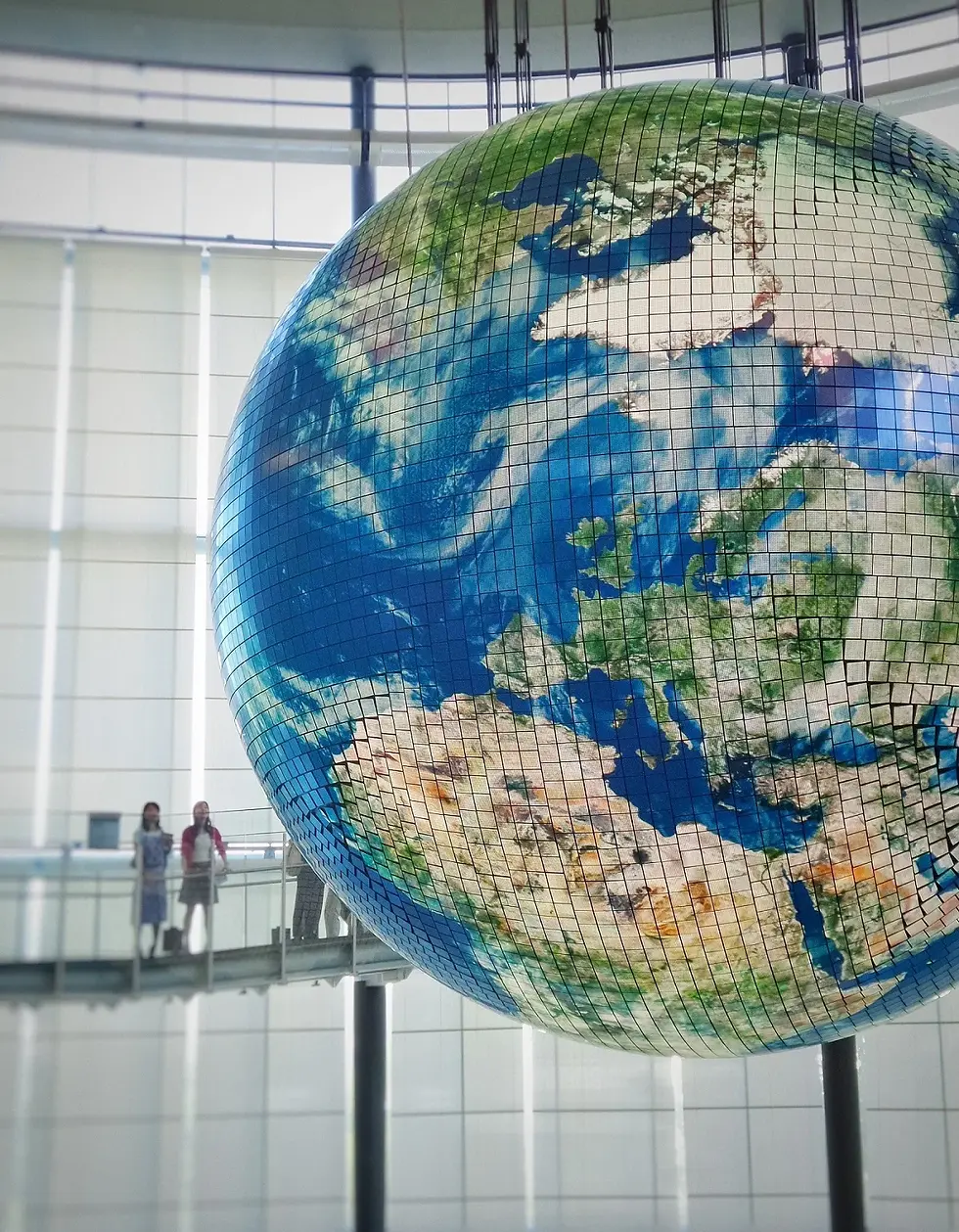 Image of two people looking at a suspended globe; sourced from company's website