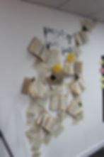 Books and pages form a wall art with "passion never fails" text. Yellow flowers and sticky notes add color to the white background.