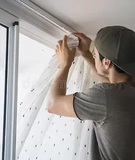 young-man-installing-curtains-over-window-handsome-handyman-home-doing-renovation-work-735