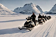 En gruppe som er på snøscootertur om vinteren