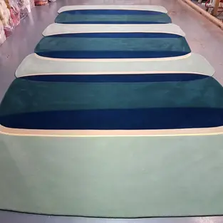 a row of green and blue striped rugs on a floor