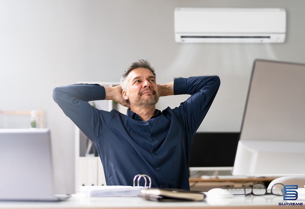 a man sitting at his desk enjoying a fresh air coming from the AC.