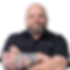 Jonathan Wells, a professional dog trainer from BetterDog, standing confidently with arms crossed. He sports a bold tattoo featuring autumn leaves and snowflakes on his forearm, wearing a black button-up shirt and glasses. His approachable yet determined expression embodies expertise and reliability.