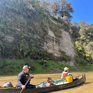 Two people canoeing down a river.