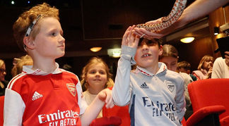 Some young football fans get up-close as they handle a corn snake at the Natural History Museum.