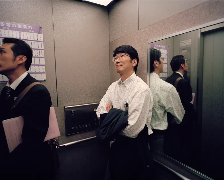 Mayor Taue of Nagasaki Japan riding in the elevator on his way to a meeting in the city office, photographed by Keith Ng on a Mamiya 7 with 50mm lens for Monocle 
