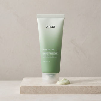 Limpiador facial Anua Heartleaf Quercetinol Pore Deep Cleansing Foam con BHA sobre base de mármol, mostrando la textura cremosa del producto para limpieza profunda de poros.