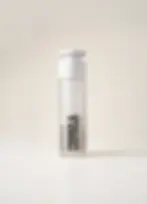 bamboo primer and moisturiser refillable bottle in studio shot with neutral cream background