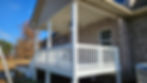 White porch construction and remodeling on a brick house.