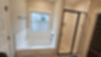 Modern bathroom construction and remodeling featuring a white tub and glass shower.