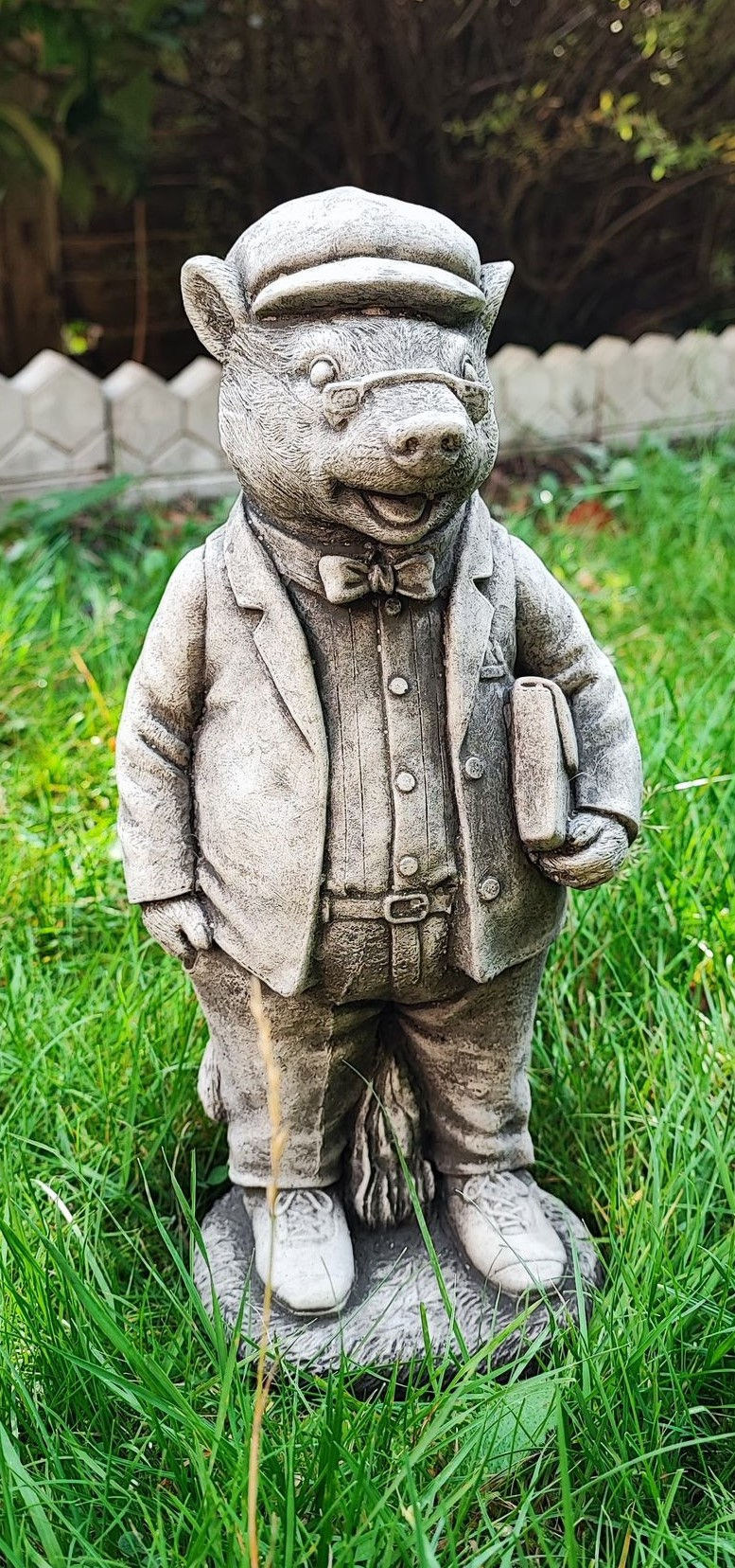 Stone statue of MR Badger - The wind in the Willows in a garden setting.