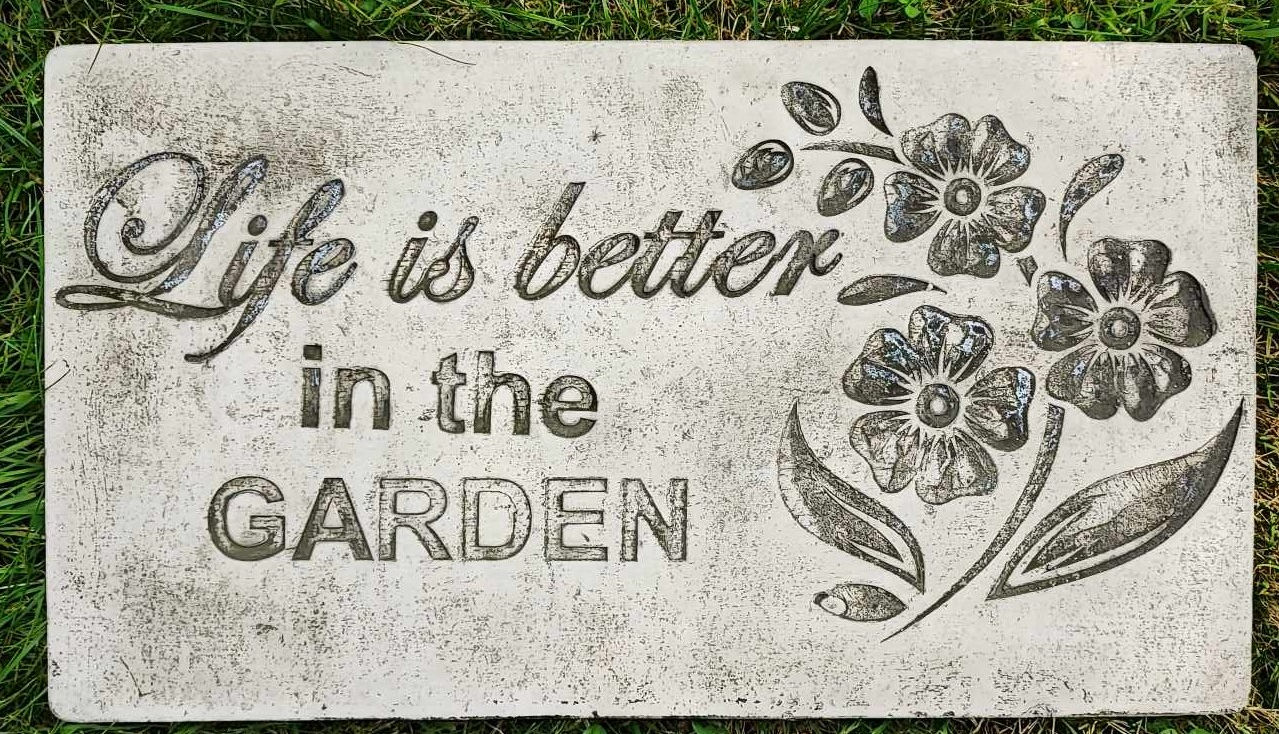Stone sign says Life is better in the garden with flowers, Life in the garden.