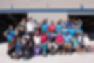 A large group of people smiling and posing together at an Ohana Day with the NAC in the background.