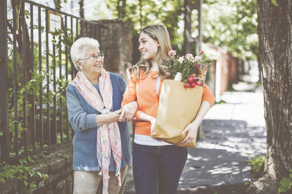senior-woman-walking-with-caregiver-groceries.jpg
