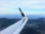 An Air NZ airplane wing in the skies over Wellington