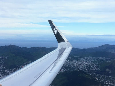 An Air NZ airplane wing in the skies over Wellington
