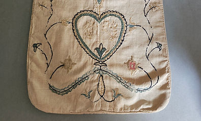 18th century linen sewing pocket embroidered with a heart set among meandering vines and flowers