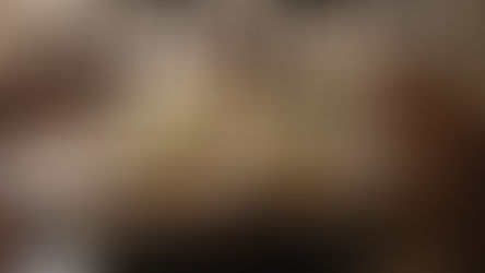 Table set with white flowers, candles, and plates on a wooden surface. Family photos in black frames adorn the wall, creating a nostalgic mood.