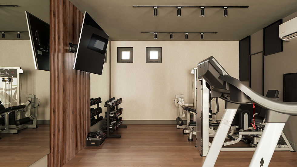 Gimnasio en casa con muros de tono neutro y piso de madera.