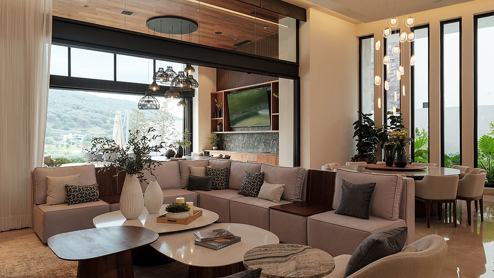 Sala de estar abierta con amplios ventanales, mobiliario contemporáneo y vistas al exterior dentro de un proyecto de diseño de interiores residencial.