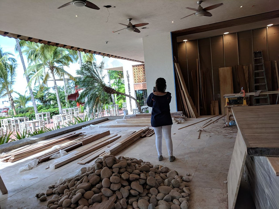 Espacio de spa en construcción con materiales de obra, maderas y vista tropical exterior que anticipa un exclusivo diseño interior de spa.