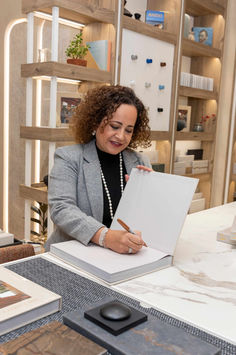 Diseñadora de interiores Victoria Plasencia firmando un libro.