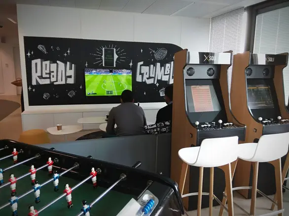 Machine d’arcade custom aux finitions bois et logo gravé, pour renforcer l’identité visuelle dans les locaux d’entreprise