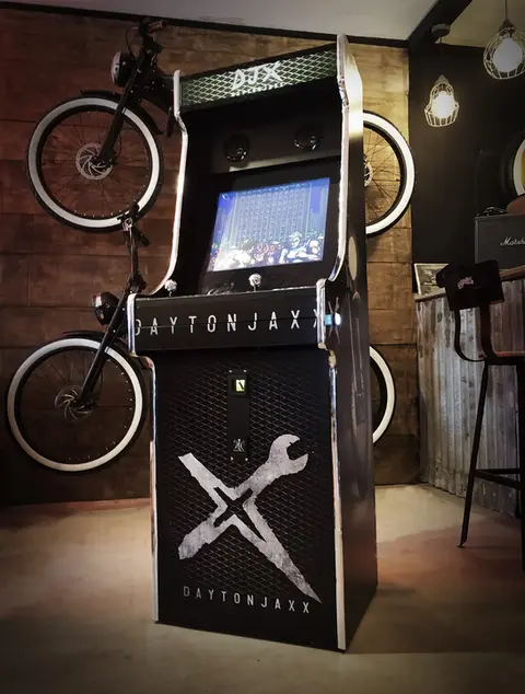 Borne d'arcade deux joueurs noire et chrome dans un atelier de vélo
