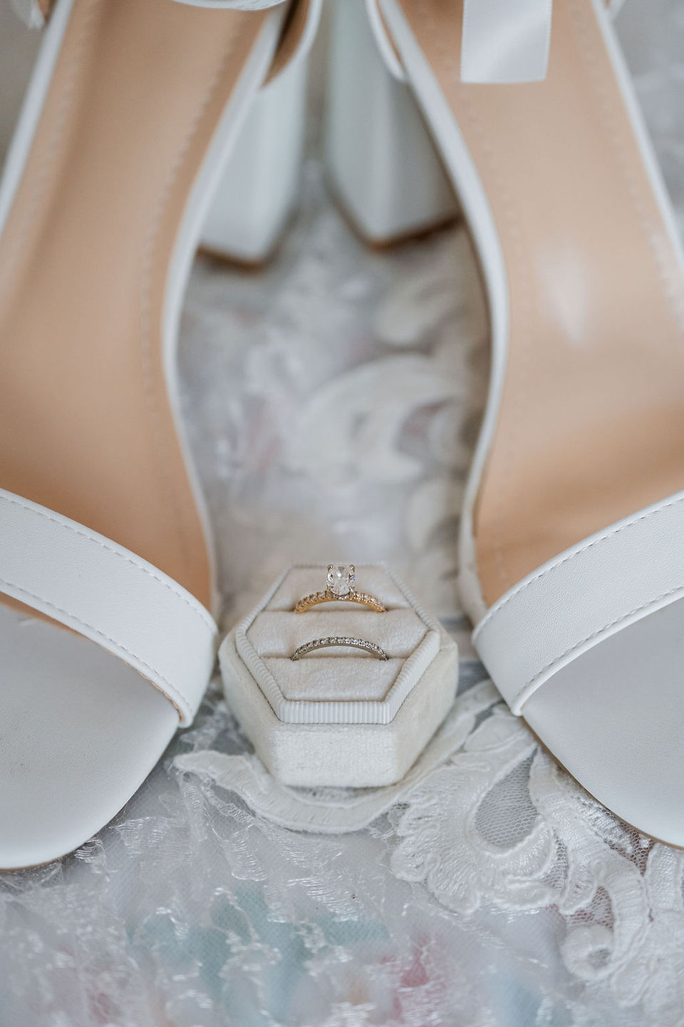 A detail photo of wedding rings and bridal shoes.