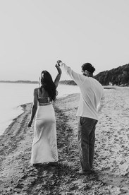 Engagement photo of a couple playfully dancing at the beach in Niagara