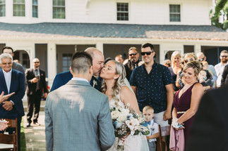A father giving his daughter a kiss on the cheek before she gets married