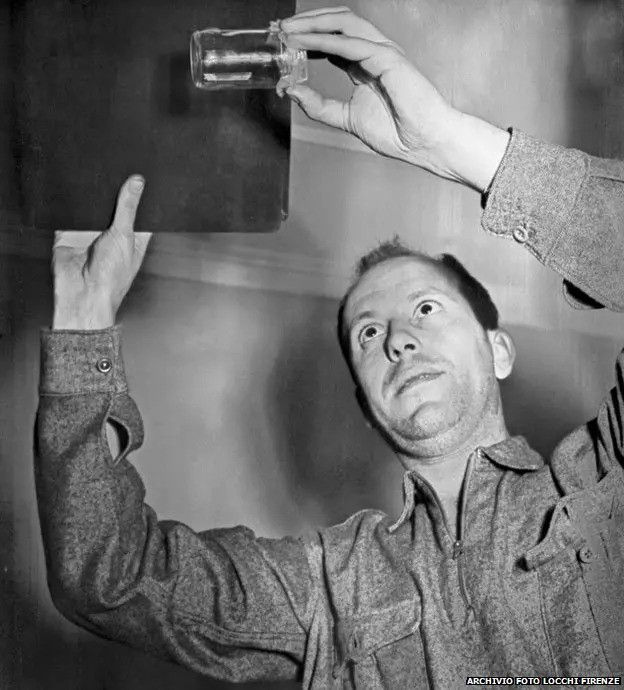person hold up glass jar with alleged angel hair.