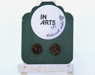 Par de brincos pequenos em forma de flor em pasta de papel cor bronze, 1cm de diâmetro, exibidos num suporte verde sobre mini cavalete.