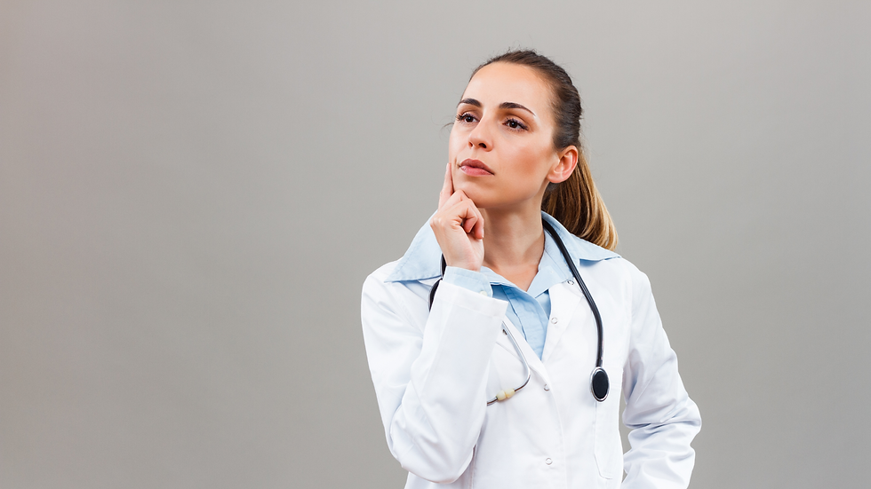Thoughtful female doctor in a white coat with a stethoscope, posing against a plain gray background.