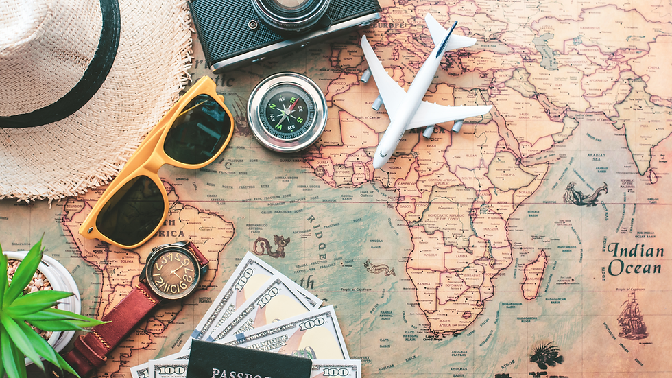 Travel flat lay on a world map: camera, toy airplane, compass, sunglasses, watch, hat, cash, and plant; Indian Ocean visible.